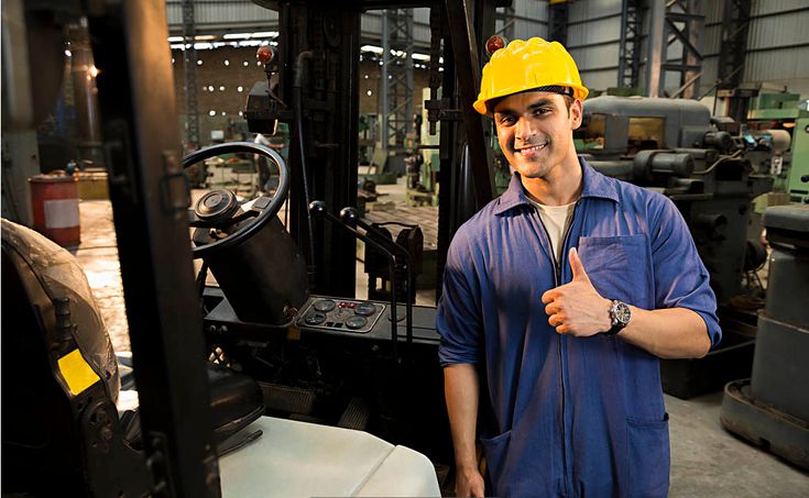Hombre con gesto positivo frente a montacargas